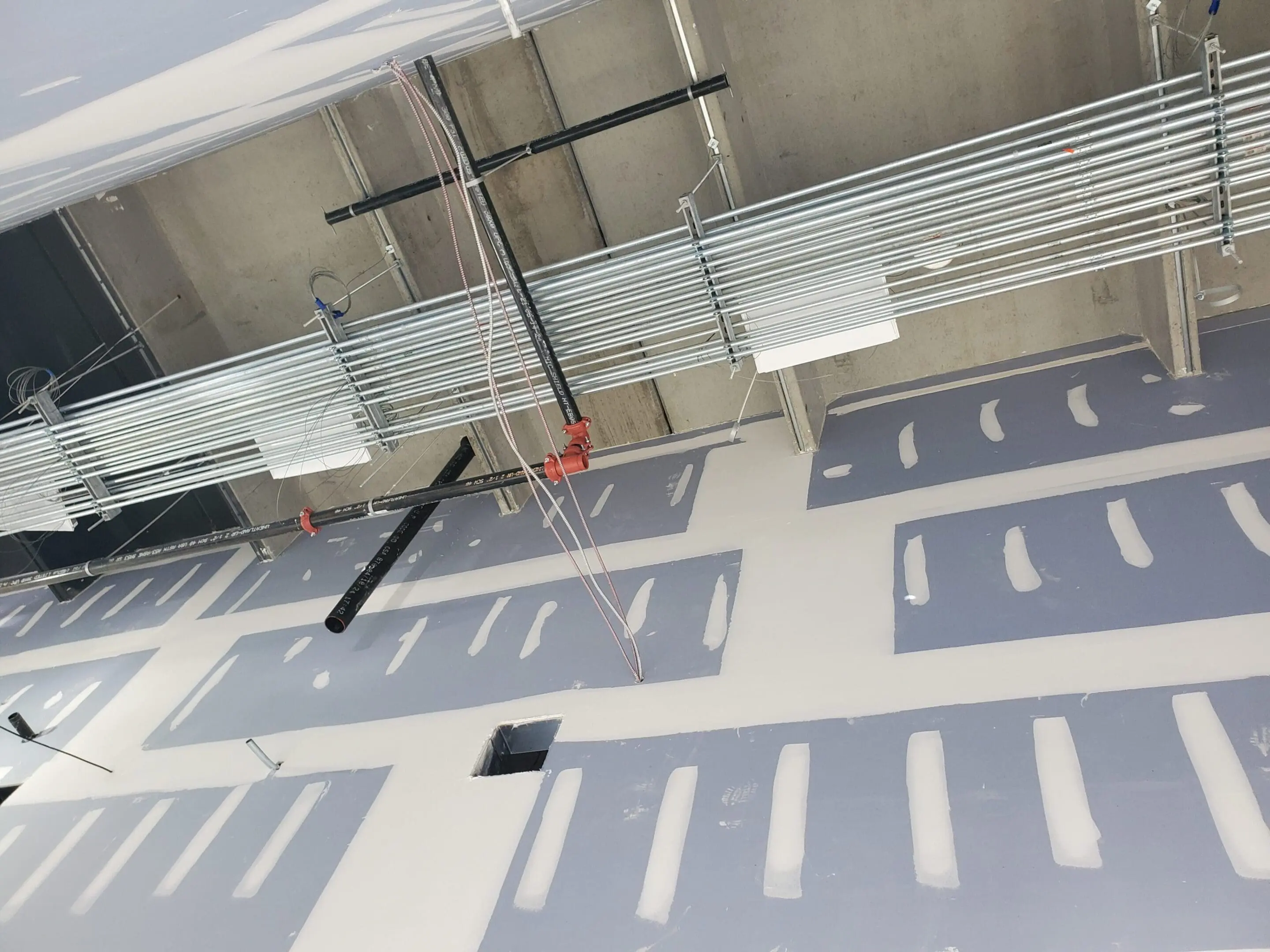 Ceiling construction with exposed ducts and pipes.