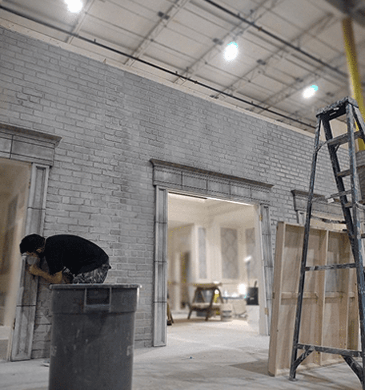Person working on interior brick wall construction.